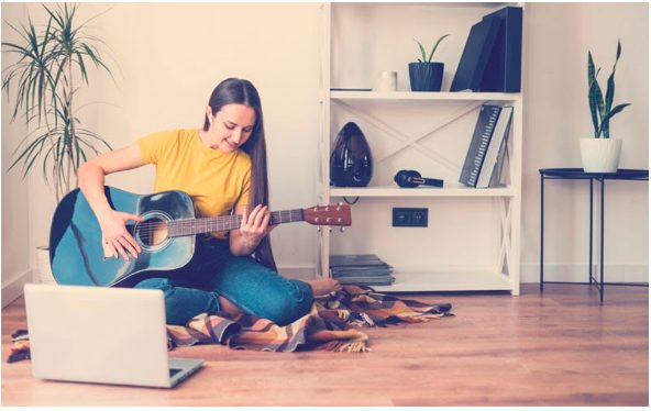 chica joven aprendiendo a tocar la guitarra