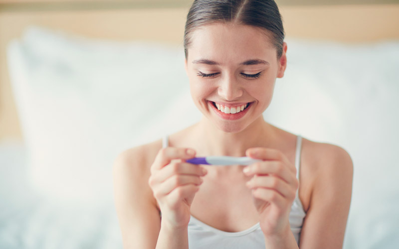 mujer joven viendo prueba despues de consejos para quedar en embarazo