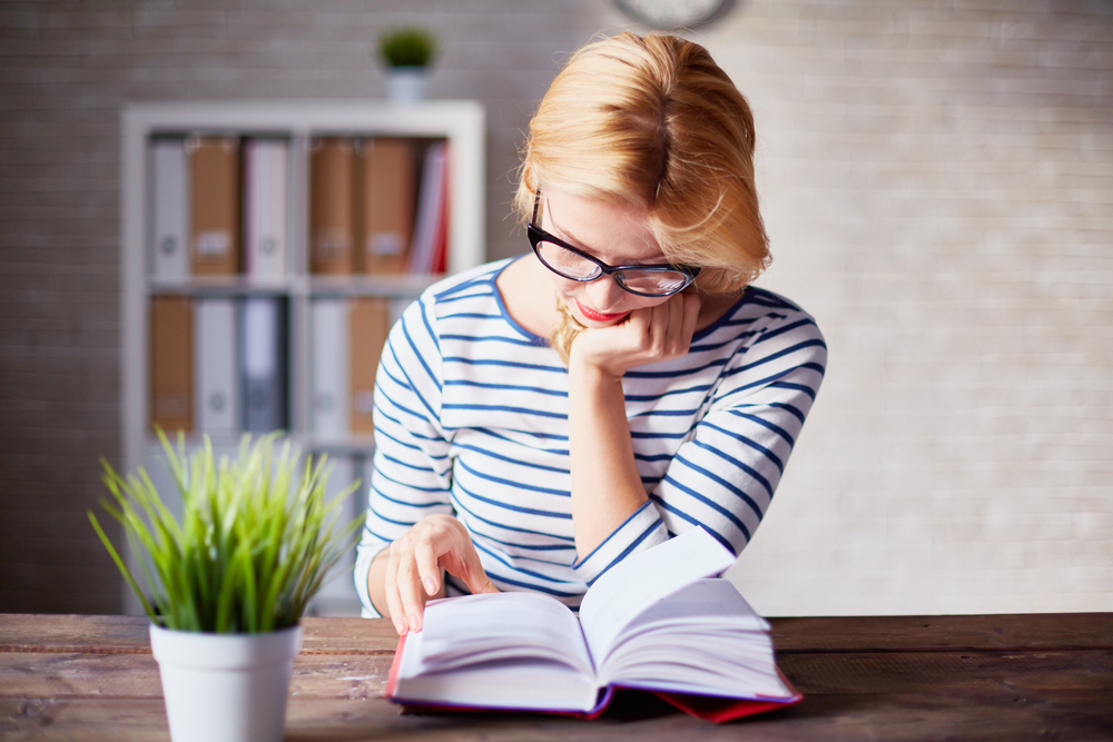 mujer rubia leyendo un libro de género literario