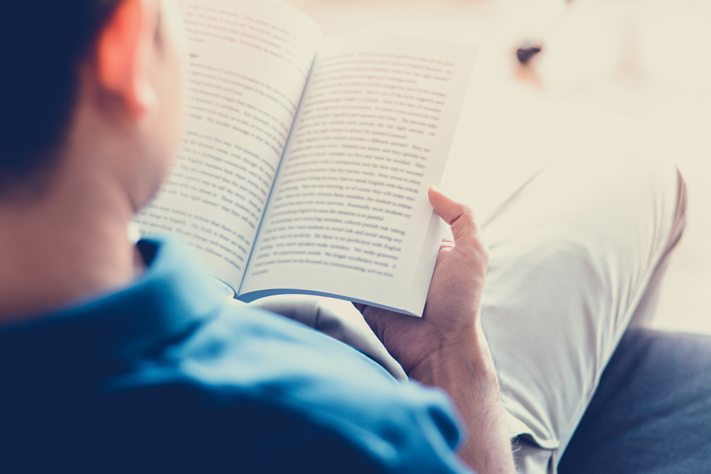 hombre leyendo un libro sobre los subgéneros literarios