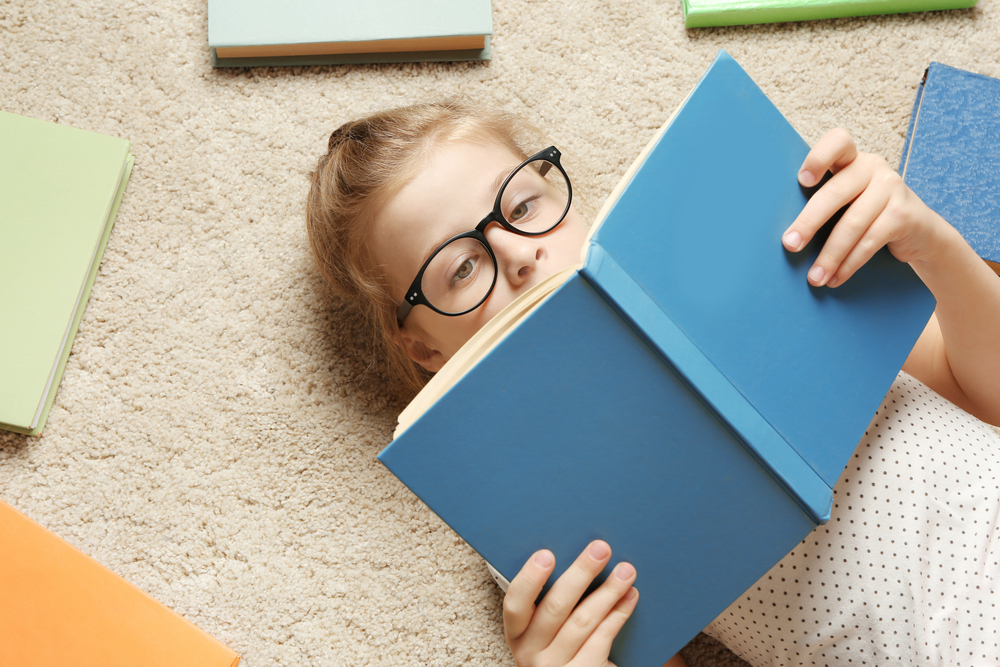 niña acostada leyendo