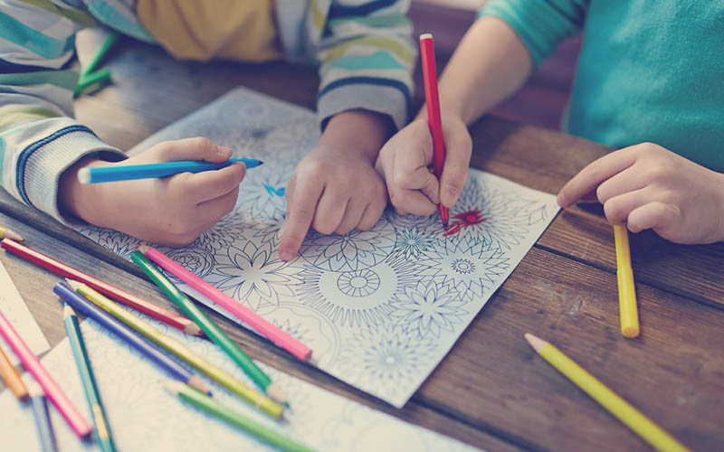  juego de niños coloreando un dibujo sobre una mesa