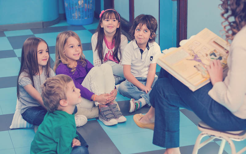 actividad lúdica de niños sentados en círculo escuchando un cuento