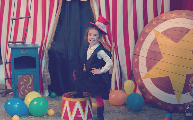 juegos de niña haciendo un dramatizado vestida de sombrero y traje en circo