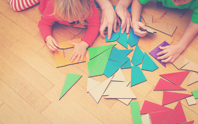 actividad lúdica de niños armando un rompecabezas de colores