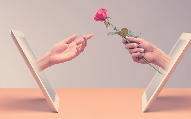 Mano del hombre presentándole una rosa a su novia de Internet