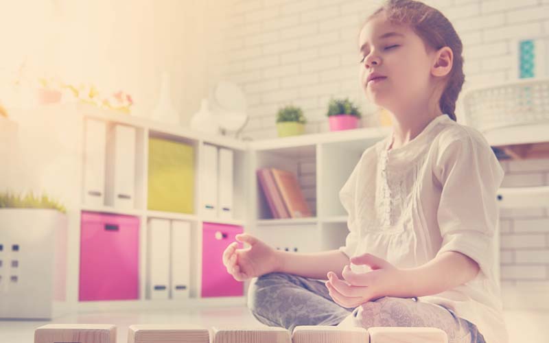 niña meditando en su cuarto