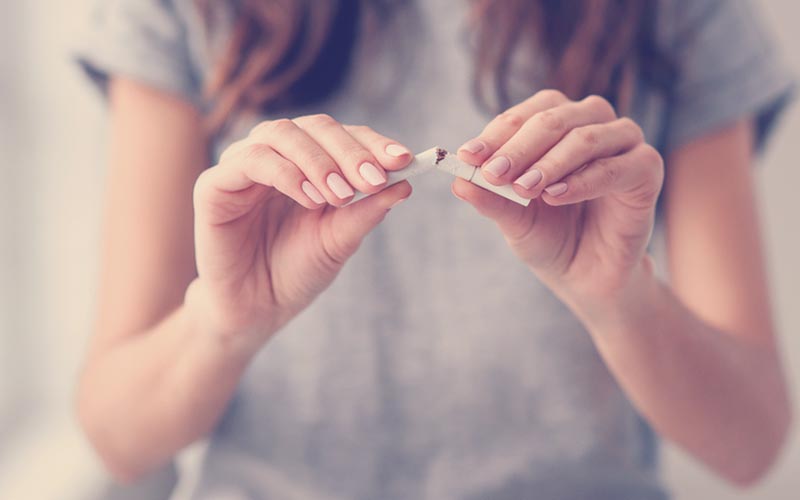 mujer con un cigarrillo en sus manos