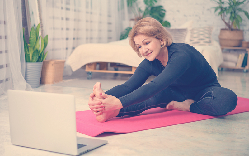 Señora practicando yoga en su casa