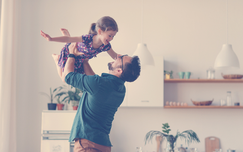 Papá jugando con su hija en el mes del padre