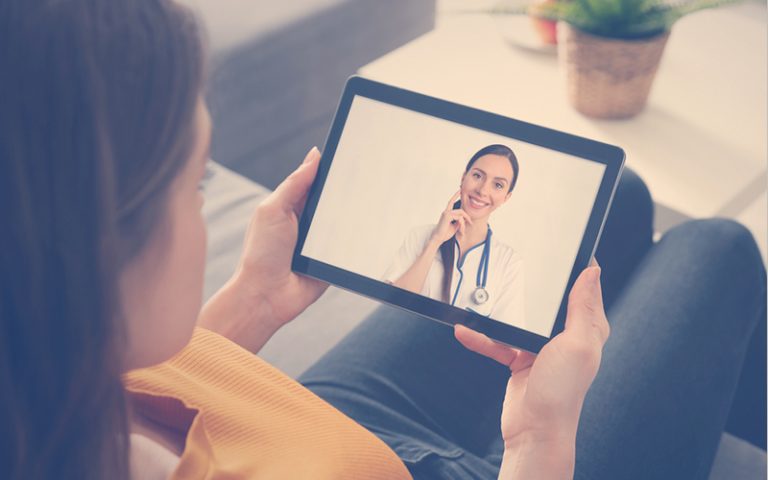Mujer con una tablet en una consulta médica virtual