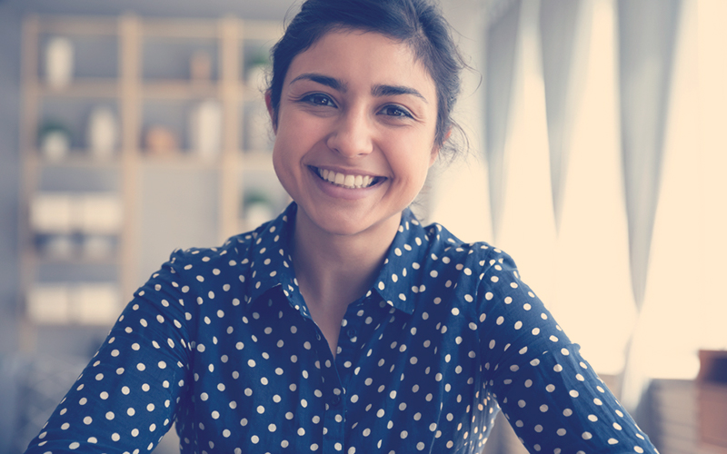 Mujer sonriendo en una videollamada de trabajo