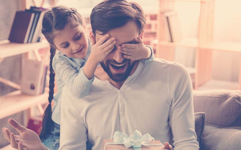 Hija entregándole a su papá un regalo