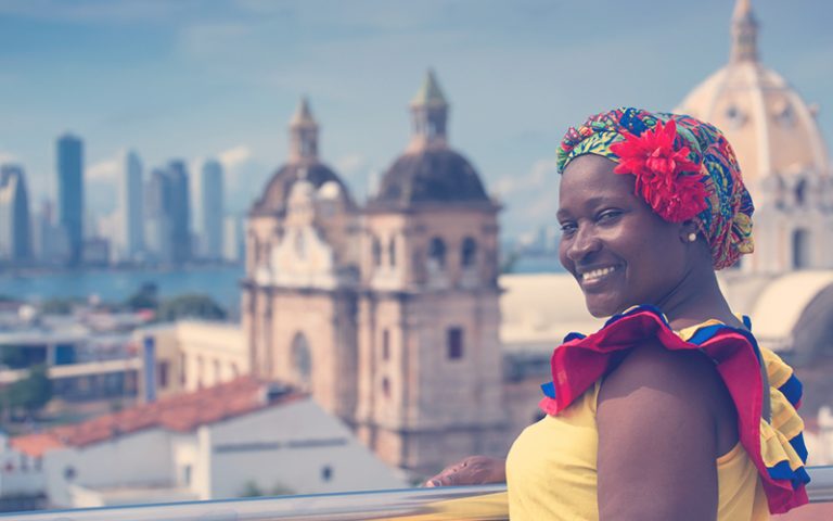 Mujer vestida de forma tradicional con el telón de fondo de Cartagena de Indias, Colombia