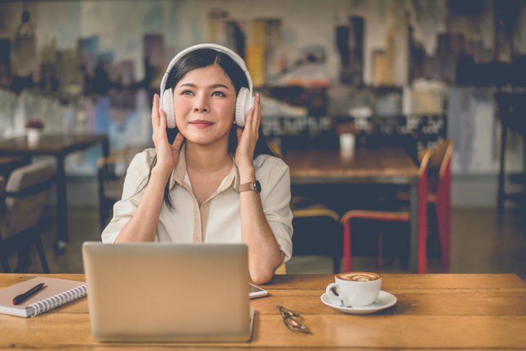 Mujer escuchando música y trabajando desde su casa
