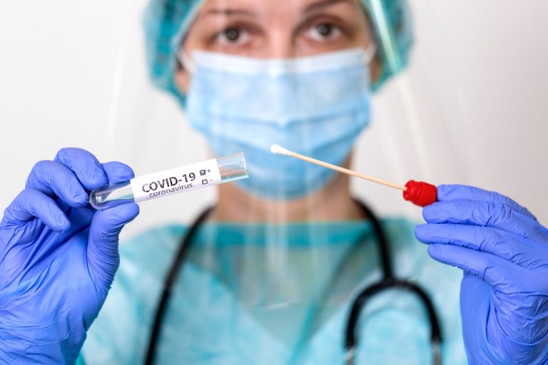 Enfermera con kit de recogida de muestras de coronavirus