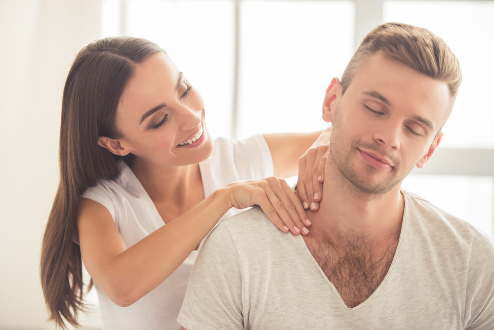 Mujer haciéndole un masaje a su pareja.