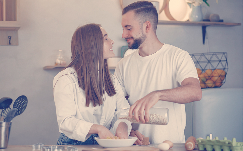 Pareja mirando cara a cara mientras cocinan juntos 