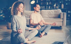 Pareja meditando en su ca