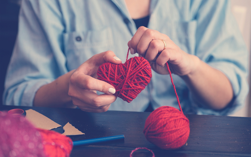 Mujer realizando una manualidad para el día del amor y la amistad o San Valentín