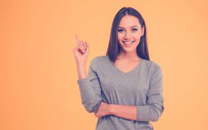 Mujer sonriendo y levantando su dedo indice