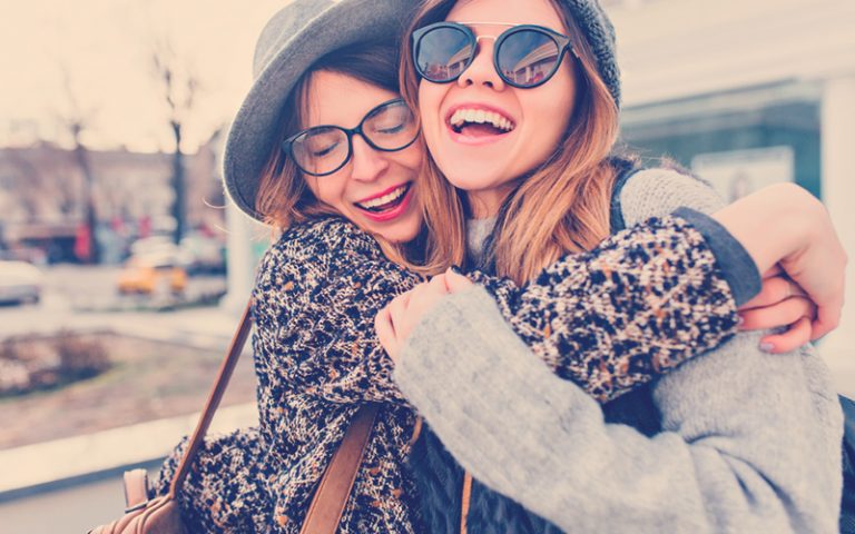 Amigas sonriendo y abrazándose