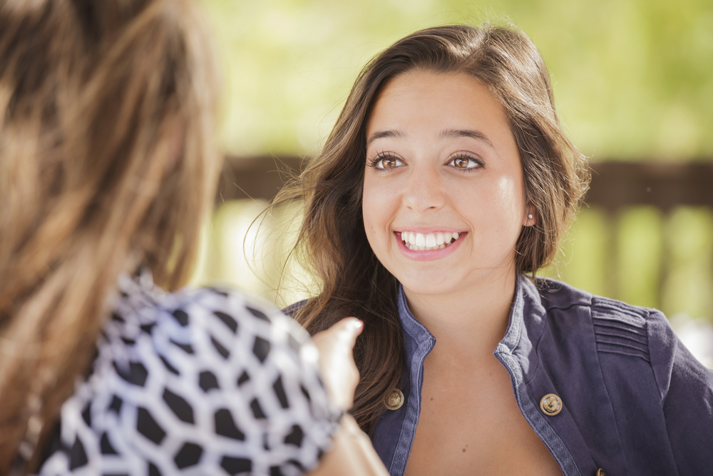 Mujer sonriente hablando con una amiga