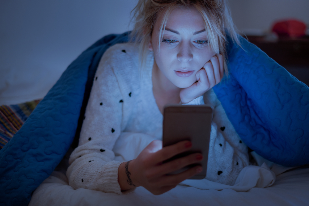 Mujer mirando su celular en la madrugada