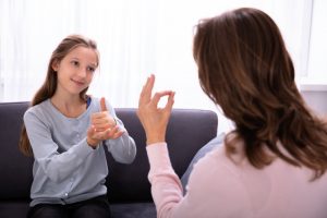 Niña utilizando la lengua de señas para comunicarse