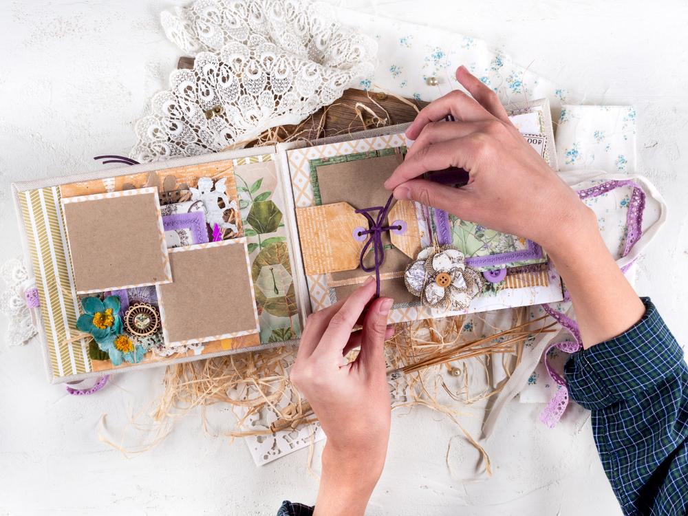 Mujer decorando un álbum de fotos hecho a mano