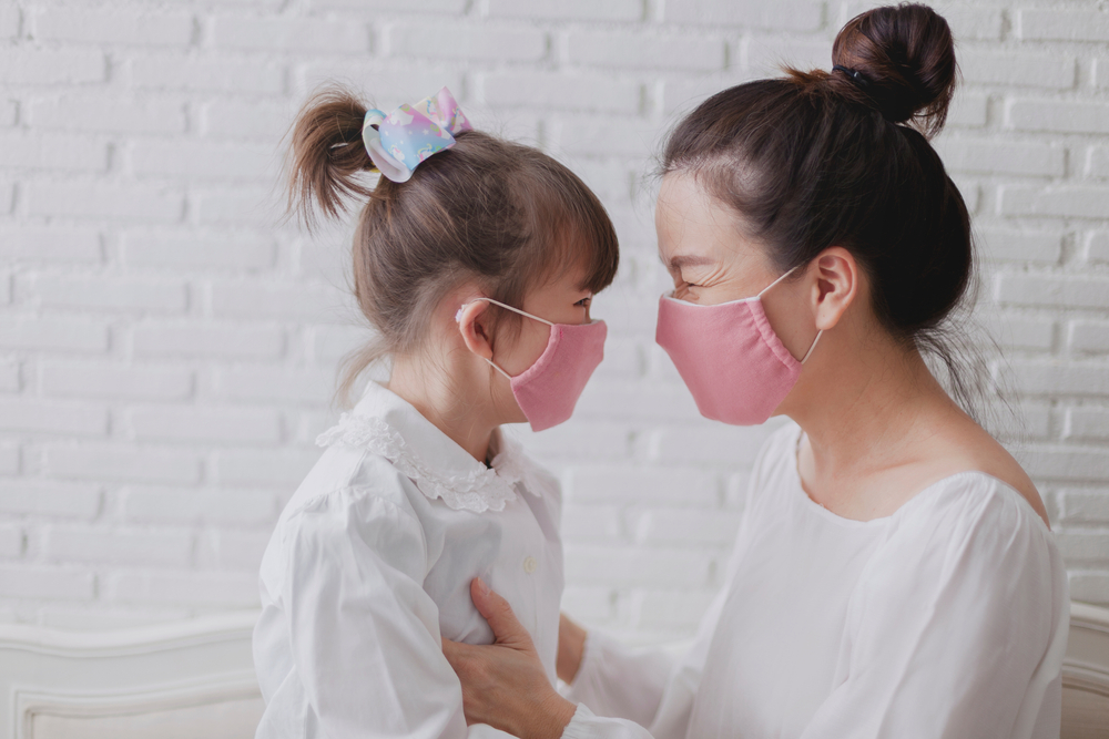 Madre e hija están contentas de usar máscara de tela hecha a mano.