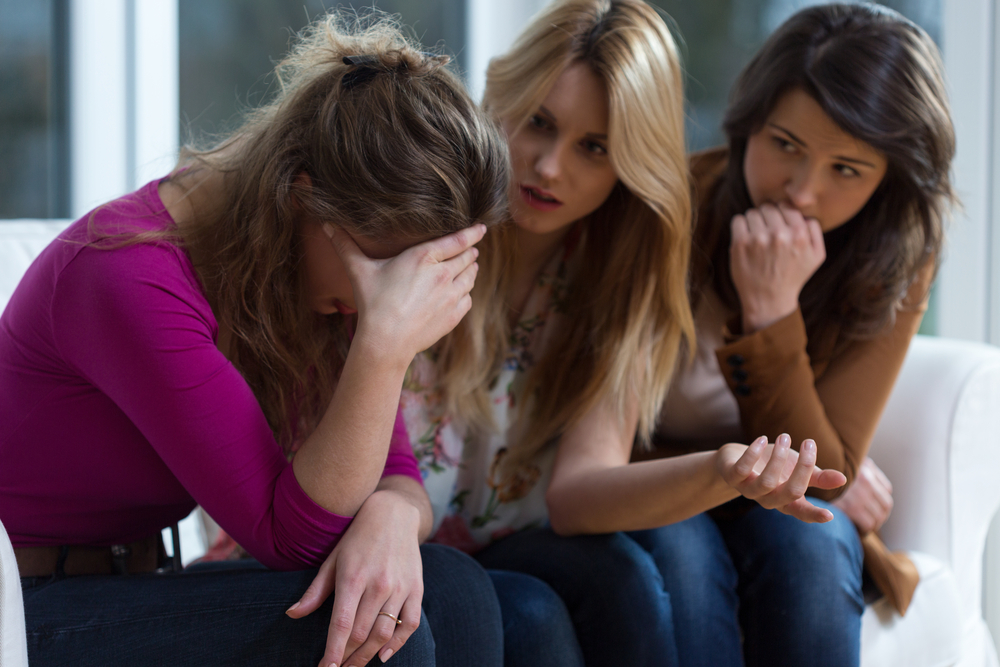 Mujer triste hablando con sus amigas 