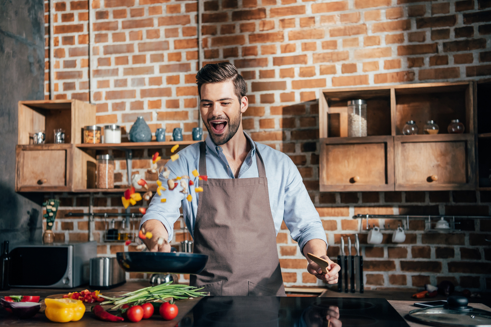 Hombre cocinando verduras al wok 