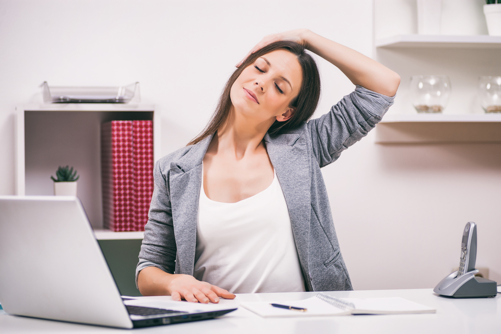 Mujer realizando pausas activas mientras trabaja 