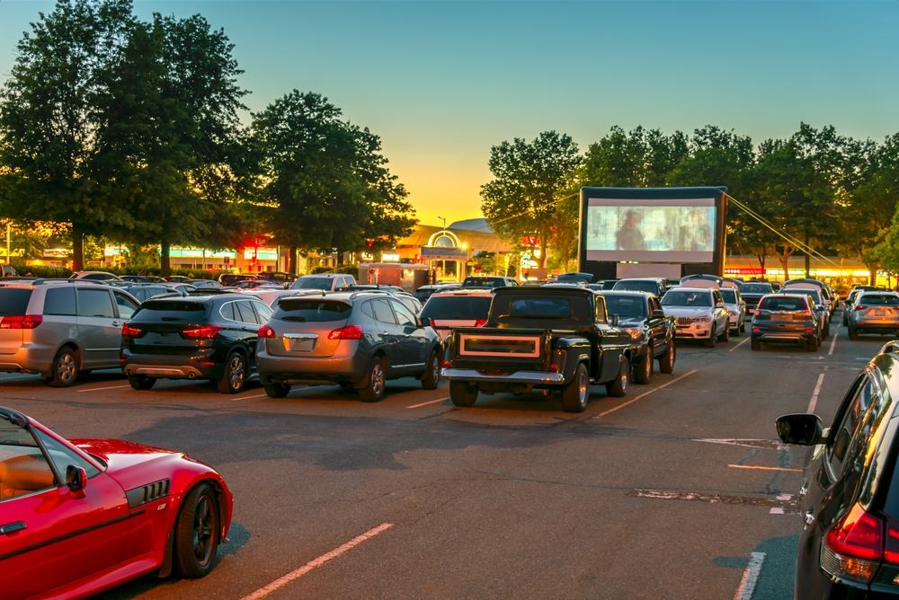 Muchas parejas en carro disfrutando del autocine