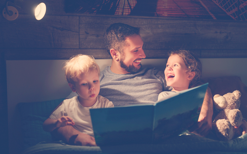 Papá leyéndole a sus hijos libros de fantasía para niños