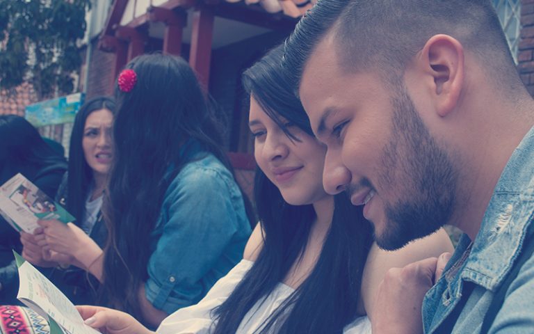 Estudiantes mirando un folleto de universidad