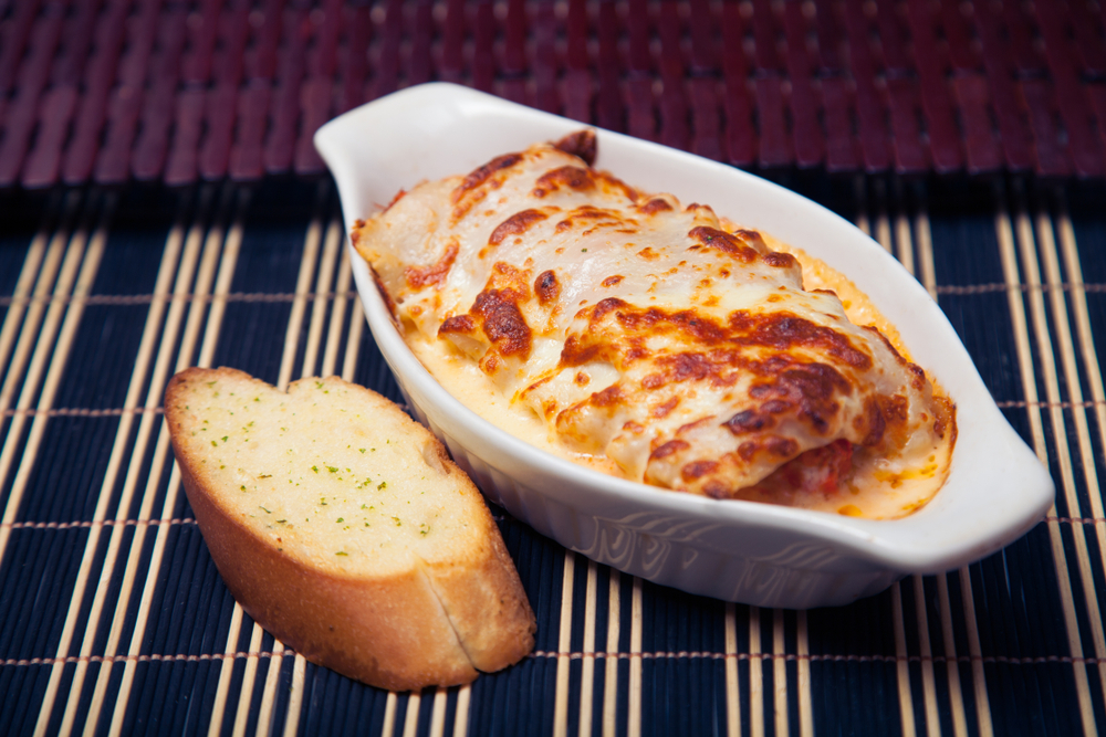 Lasaña mixta  acompañada de un pan de ajo 