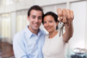 Pareja feliz con las llaves de su casa propia