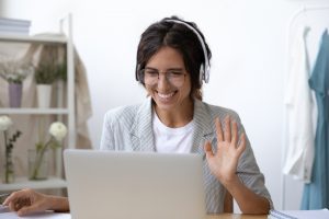 Mujer sonriendo y conectada a una reunión virtual