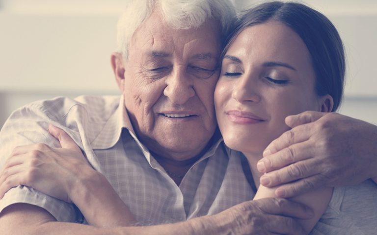 Padre e hija abrazándose mientras sonríen