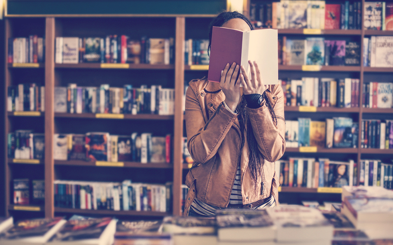 Mujer en la biblioteca leyendo un libro