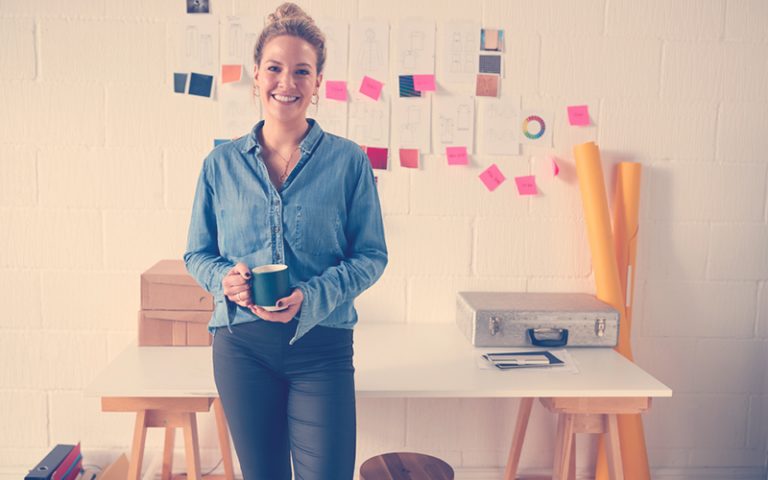 Emprendedora sonriendo con un café en la mano