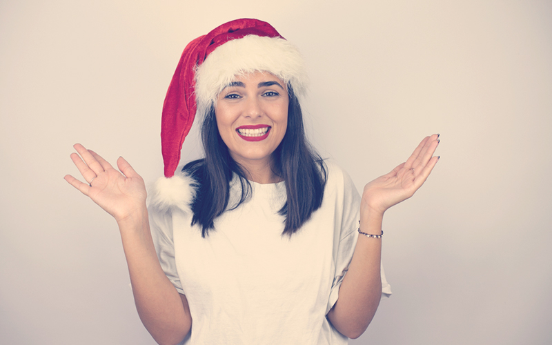 Mujer sonriendo con un gorro de Navidad