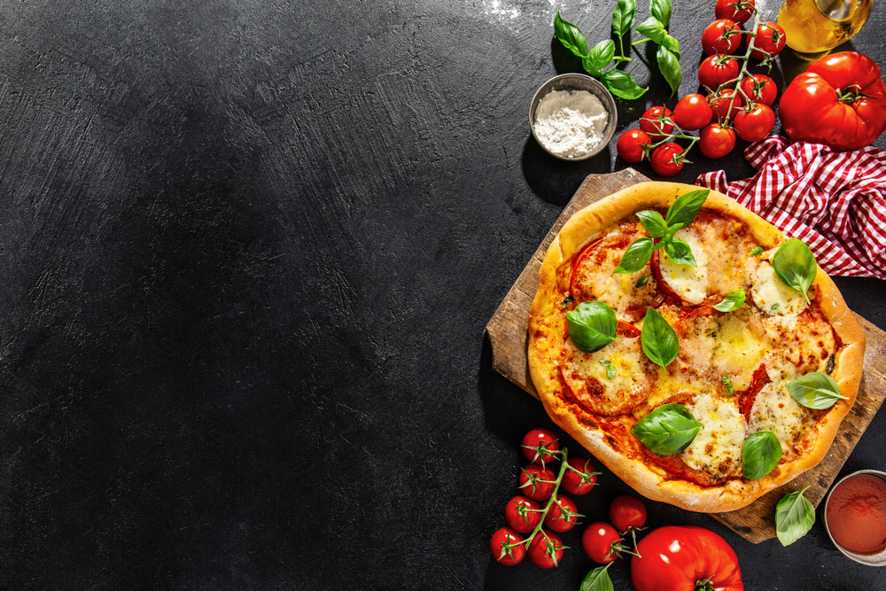 Sabrosa pizza vegetariana casera servida en un fondo oscuro.