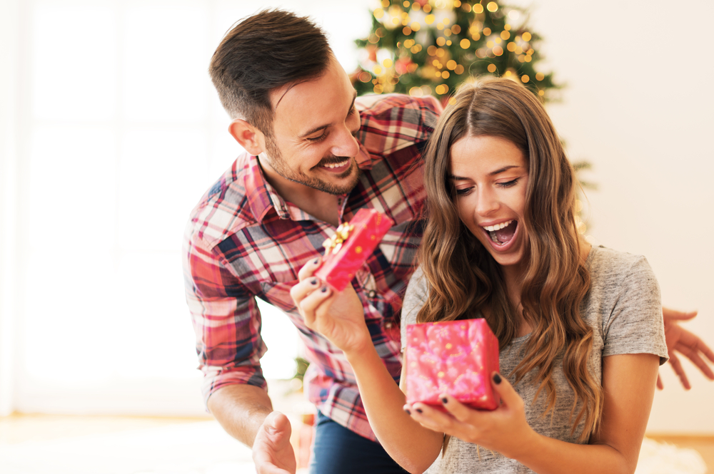 Hombre dándole un regalo de Navidad a su novia