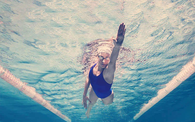 Mujer nadando y conociendo los beneficios de practicar natación