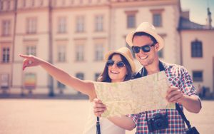 Pareja feliz revisando un mapa en un viaje turístico