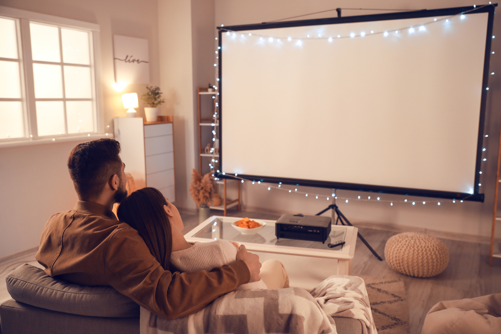 Joven pareja viendo televisión en su casa