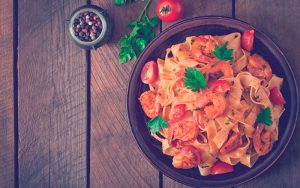 Fettuccine pasta con camarones, tomates y hierbas.